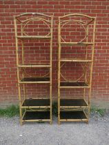 A pair of tall vintage bamboo shelving units, each housing five smoked glass loose shelves.