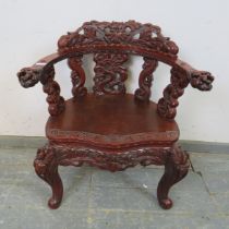 An antique Chinese lacquered tub chair, having intricately carved & pierced backrest in high relief,