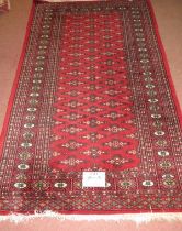 A 20th Persian rug, central field of repeat pattern on red ground. 163cm x 96cm (approx).