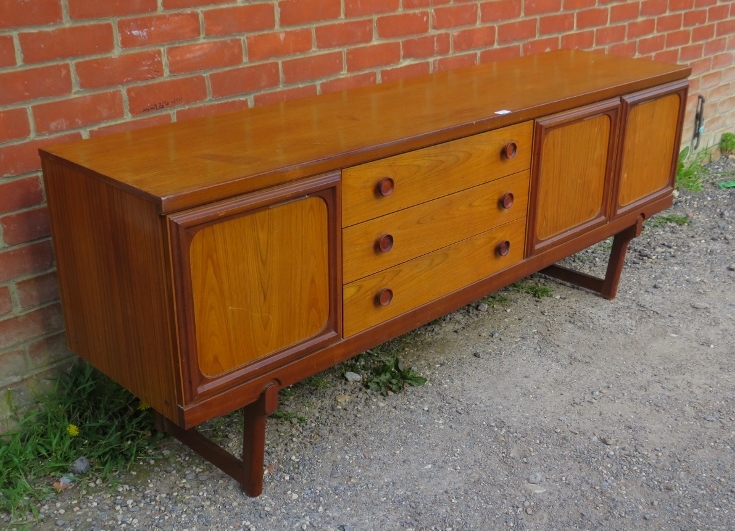 A mid-century teak sideboard, having three short drawers with turned wooden handles, flanked by - Bild 2 aus 3
