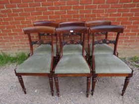 A set of six Victorian rosewood dining chairs, having ornately carved and pierced backs, above