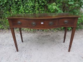 An antique Regency Revival mahogany serpentine fronted serving table, housing three short drawers