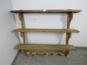 A rustic Continental antique pine wall-mounting set of three open shelves with shaped brackets