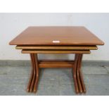 A set of three mid-century teak graduated nesting tables by G-Plan, on curved supports with