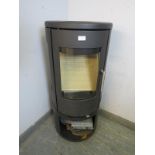 A contemporary cast-iron multifuel stove by Morso (model 7443) having a curved glass door with