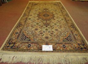 A Persian design rug, central motif, surrounded by repeat fawn, cream & brown. 176cm x 94cm (