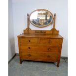 An Art Deco Period medium oak dressing chest, the bevelled oval swing mirror above a base housing