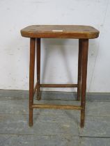 A vintage stained pine artist’s stool, on canted supports with stretchers. H60cm W33cm D20cm (