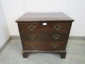 A George III straight front mahogany chest of small proportions, housing three long drawers with