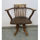 An Edwardian elm captain’s swivel desk chair, on four shaped supports. H79cm W65cm D48cm (approx).