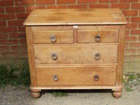 An antique pine chest, housing two short above two long graduated drawers with fluted glass knob
