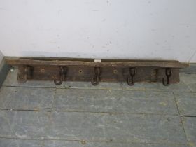 A rustic antique oak wall mounting shelf, fitted with five cast iron rotating coat hooks. H14cm