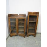 Two vintage oak glazed bookcases, with ¾ galleries, housing two and three shelves respectively, on