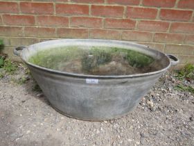 A vintage galvanised tub garden planter, with handles to either side and drainage hole to base.