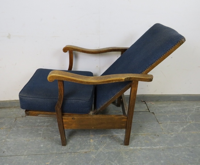 A 1920s oak reclining open-sided armchair, upholstered in navy material with brass studs, the shaped - Image 3 of 4