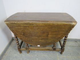 An antique oak oval gate-leg table, on barley twist supports with stretchers. H72cm W102cm D47-133cm