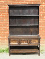 A 19th century oak kitchen dresser in a 17th century taste, the moulded cornice above two open