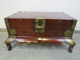 A Chinese hardwood chest, having engraved brass mounts, the hinged top compartment above one long