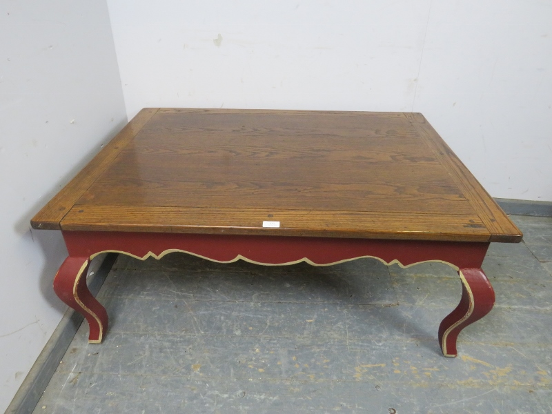 A reproduction oak rectangular coffee table, the burgundy painted base with shaped frieze above ogee