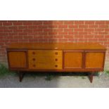 A mid-century teak sideboard, having three short drawers with turned wooden handles, flanked by