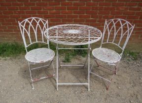 A steel garden set painted white comprising a circular folding table with radial wirework