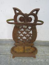 A cast iron stick stand in the form of an owl, with removable drip tray. H48cm W33cm D17cm (approx).