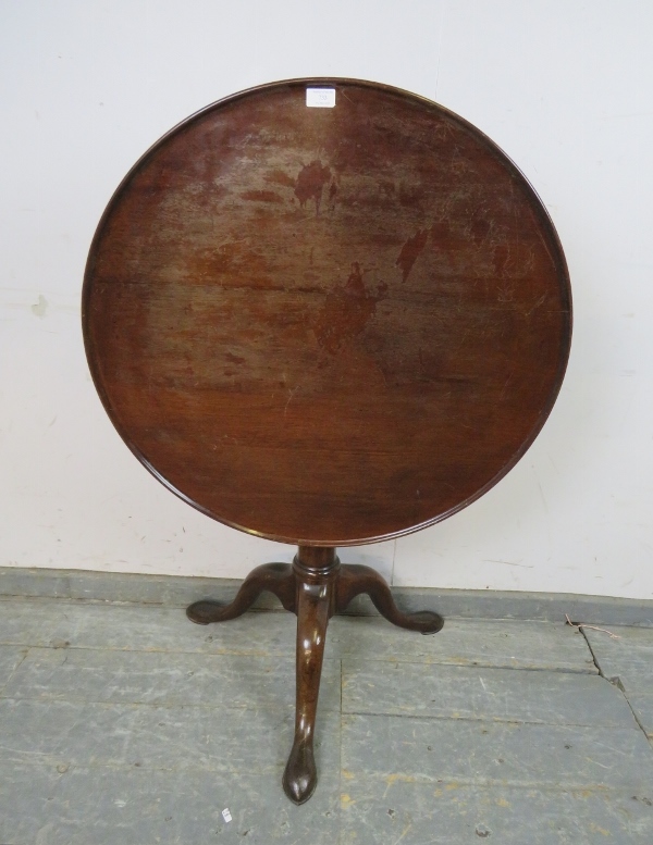 A George III mahogany ‘birdcage’ tilt-top table, the dished top above a plain tapering column with