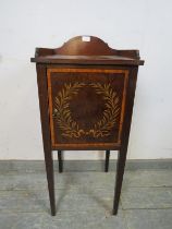 An Edwardian mahogany bedside cabinet, having a shaped ¾ gallery above a crossbanded door with