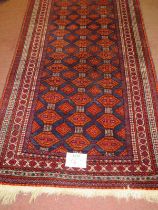 A 20th century Persian rug, central field of repeat pattern, orange/red on blue ground. 180cm x 96cm