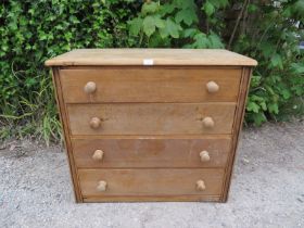 An antique light oak shaker style chest housing four long drawers with turned wooden knob handles.