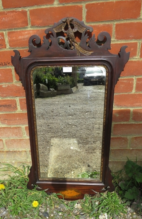 A Georgian mahogany parcel gilt bevelled wall mirror, the shaped and pierced surround with a