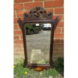 A Georgian mahogany parcel gilt bevelled wall mirror, the shaped and pierced surround with a