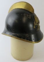 A 1930s German black and brass fire helmet with crossed axe badge