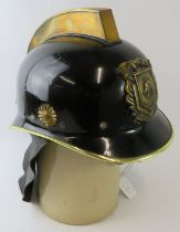A 1970s Dutch Fire Service black steel fire helmet with brass mounts and leather neck cowl