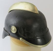 An early 20th century German black leather fire helmet with white metal mounts