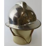 A 1980s French Paris Fire Service polished chrome fire helmet with brass mounts