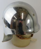 A 1980s West German polished chrome fibreglass fire helmet with leather neck cowl