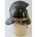 A 1920s British leather and brass Hendry fire helmet with crossed axe badge