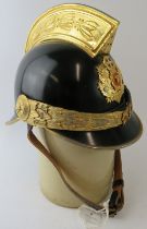 A Greek Athens Fire Brigade black steel fire helmet with brass mounts and badge