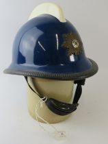 A 1970s Norwegian Fire Service blue fibreglass fire helmet with white comb and mounted badge