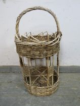 A vintage French two-tier wicker picnic basket, the top section with woven gallery above a wine