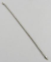 An 18ct white gold diamond line or tennis bracelet, the 60 round brilliant cut diamonds bezel set in
