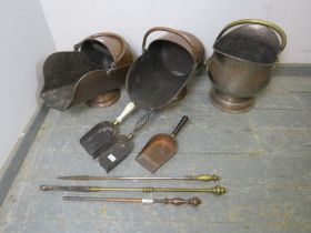 A mixed lot of antique brass and copper comprising three coal scuttles with scoops and three pokers.