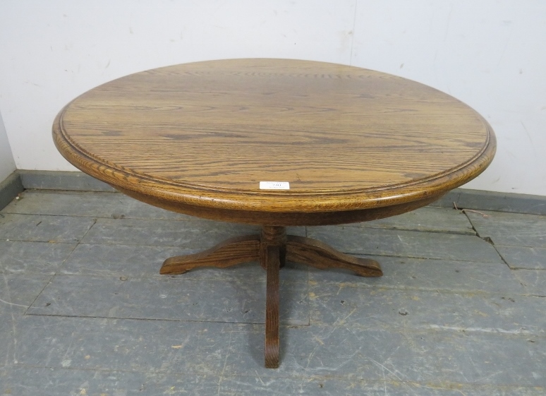 A vintage solid medium oak circular coffee table, on a bulbous turned column with quatreform base.