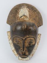 Tribal Art: An African Ivory Coast carved and painted wood mask, Baule/Guro people. 33.5 cm