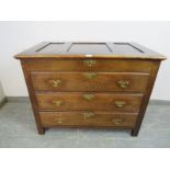 An antique oak chest in the 18th century taste, the panelled lid opening onto a shallow compartment,