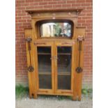 An Arts & Crafts light oak glazed cabinet in the manner of Glasgow school, the stepped cornice above