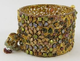A decorative 22ct gold Indian wide hinged bangle, of openwork design all over set with facet cut