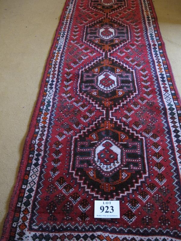 A mid 20th Century Turkish runner. Five central interlocking medallions on a red ground 290 x