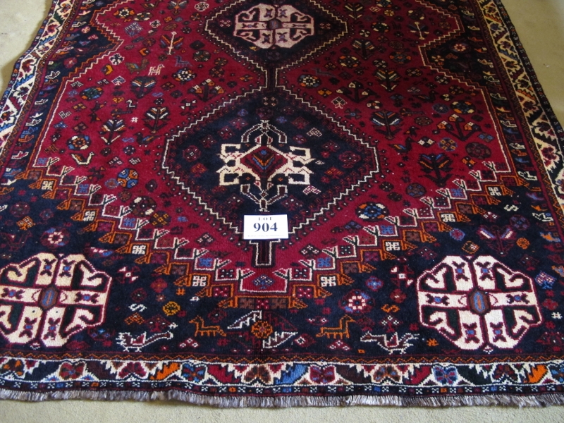 A fine South West Persian Qashqai rug. Three centred triangle motifs on red ground. 240cm x 165cm (